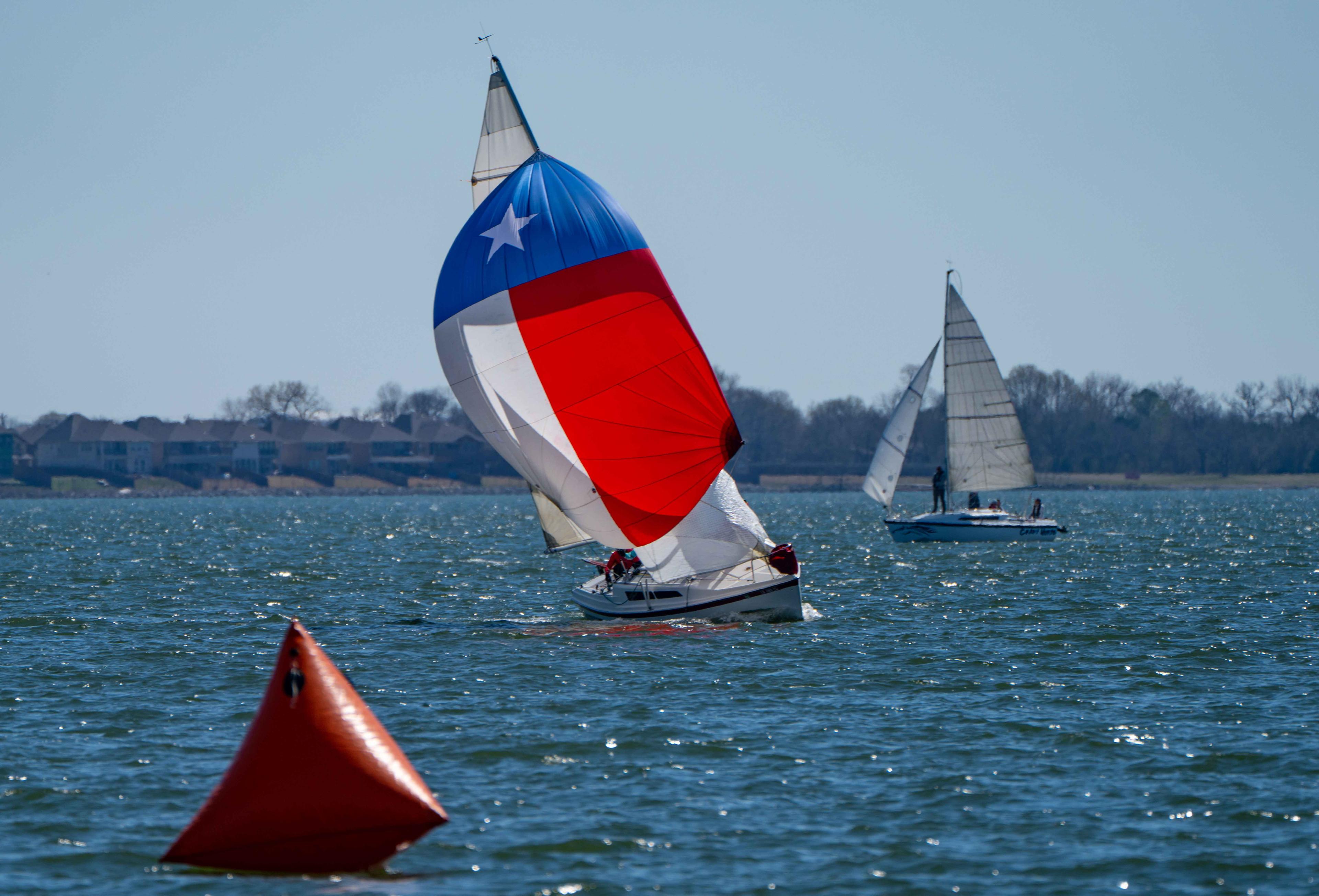 Keelboat rounding a mark flying a Texas-flag spinnaker at Rush Creek