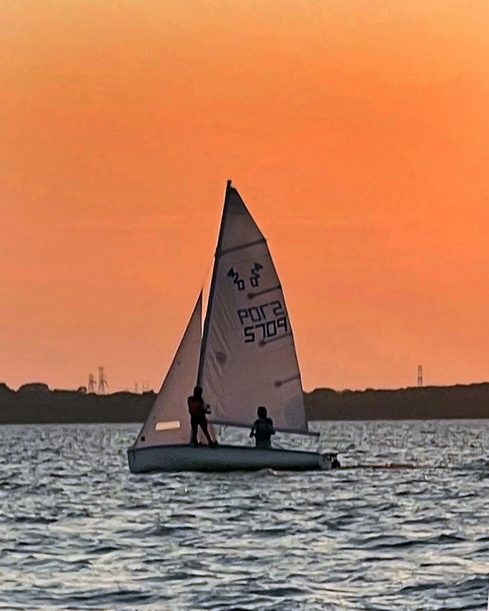 Club 420 sailing silhouetted against a sunset on Lake Ray Hubbard