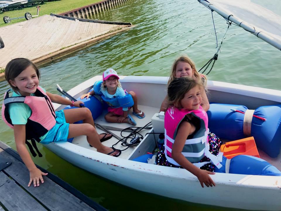 Young Tadpoles sailors in a dinghy at the Rush Creek dock