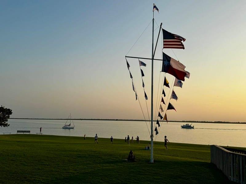 Club burgees flying on the lawn at Rush Creek Yacht Club at dusk