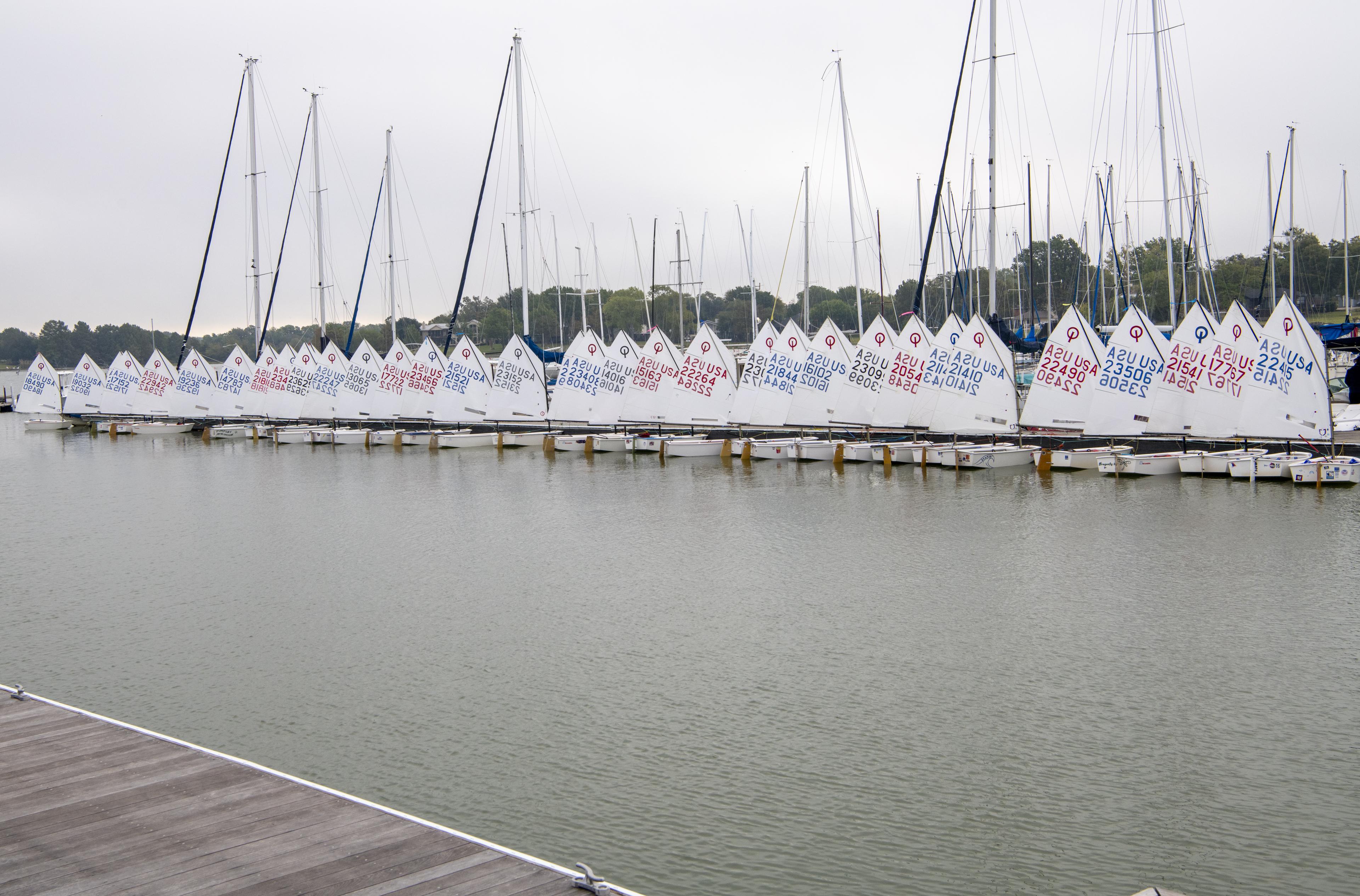 Large Optimist fleet lined up at the dock for a regatta at Rush Creek