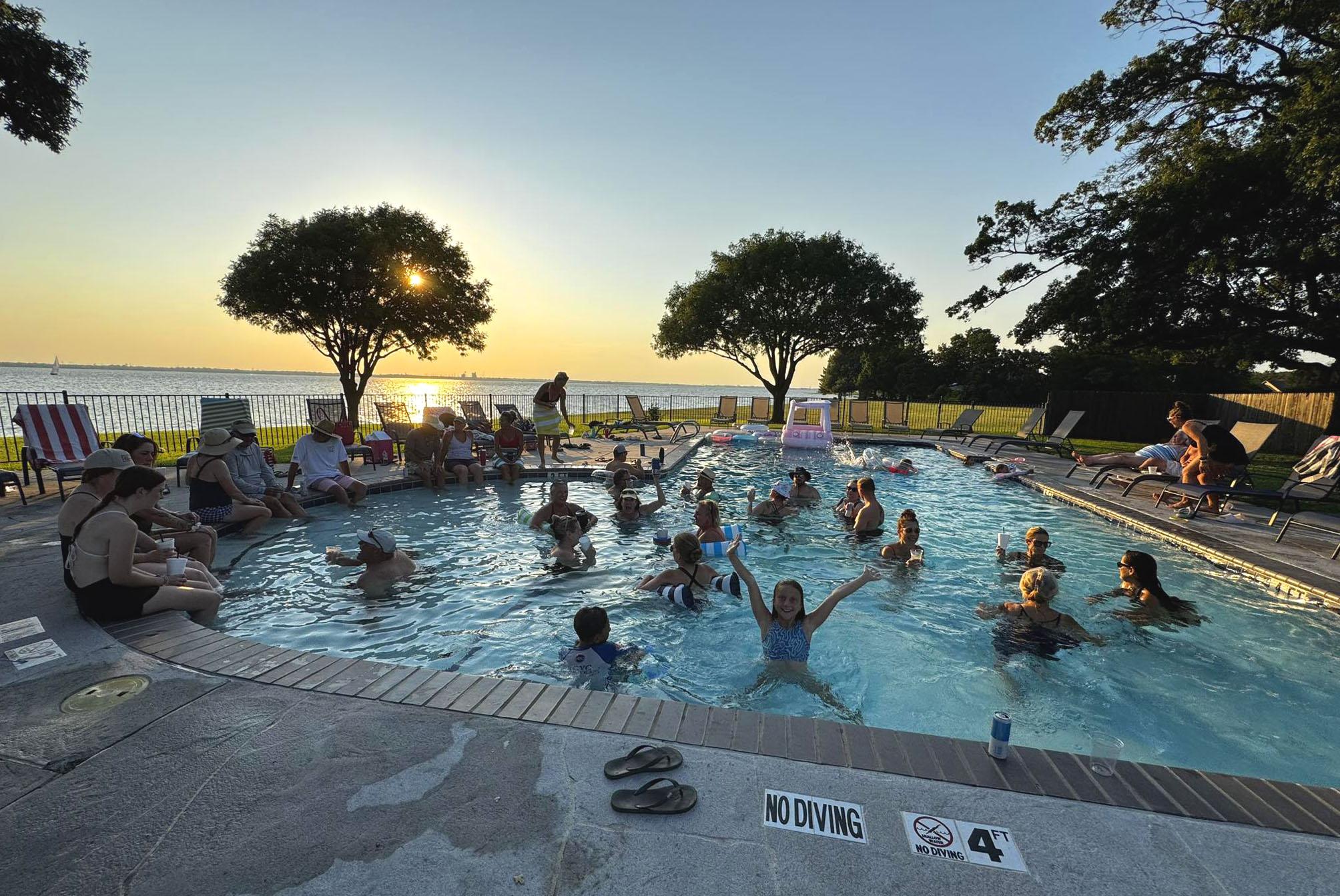 Members enjoying a pool party at sunset at Rush Creek Yacht Club