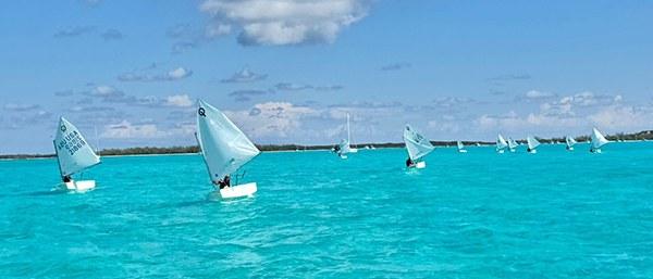 RCYC Optimist sailors racing in turquoise waters at the Exuma Regatta