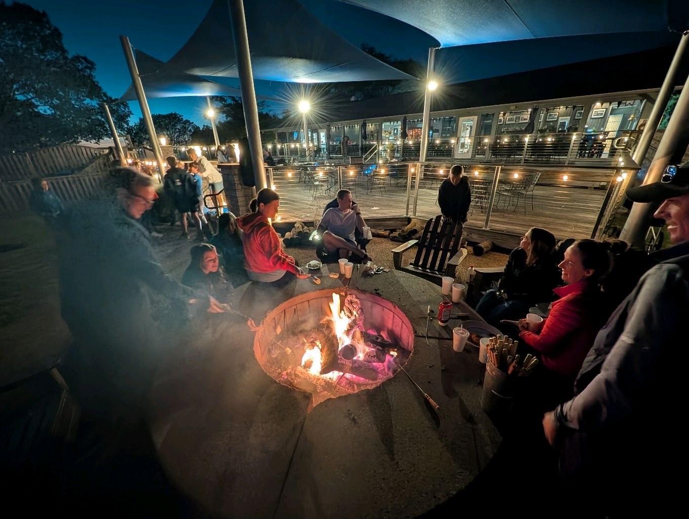 Youth sailors and families gathered around the bonfire on the Rush Creek deck